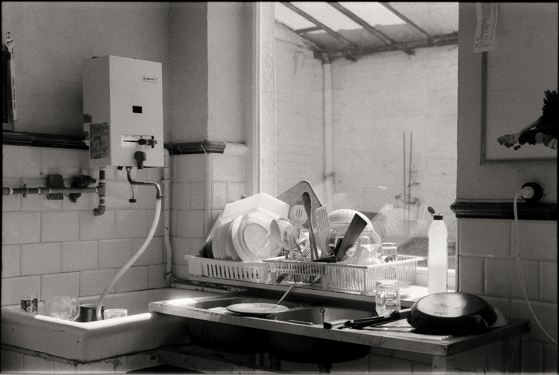 A black and white photo of a kitchen sink filled with dishes