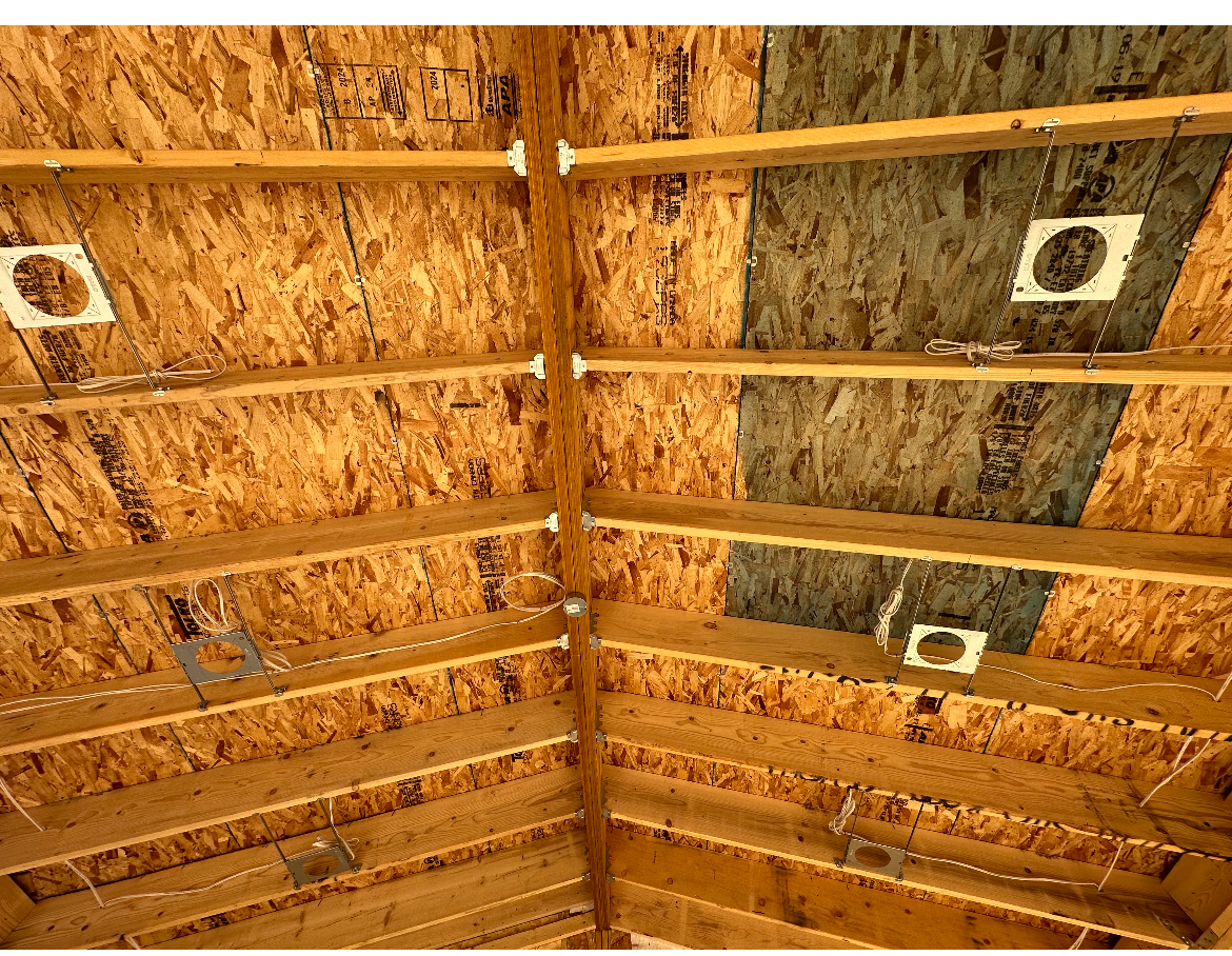 Wooden roof frame with insulation and circular vents.