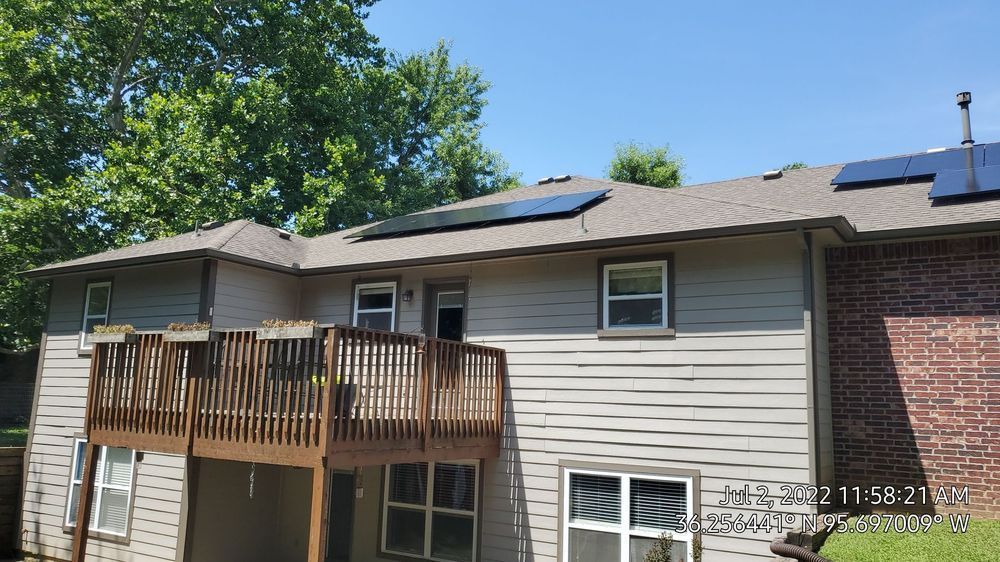 A house with a deck and solar panels on the roof