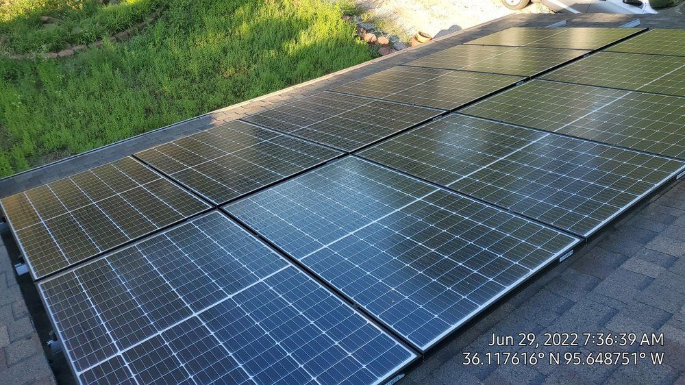 A row of solar panels are sitting on top of a roof.