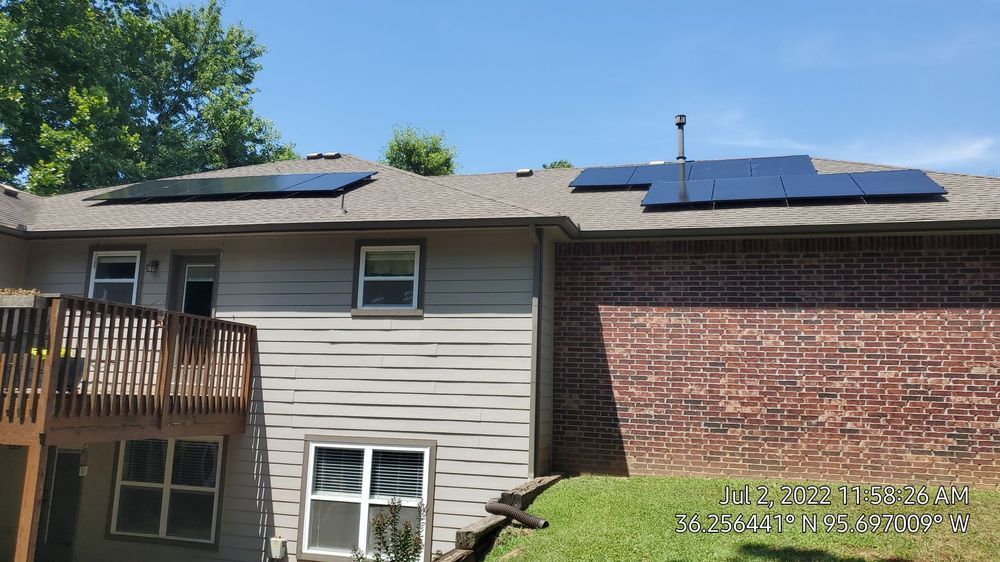 The back of a house with solar panels on the roof.