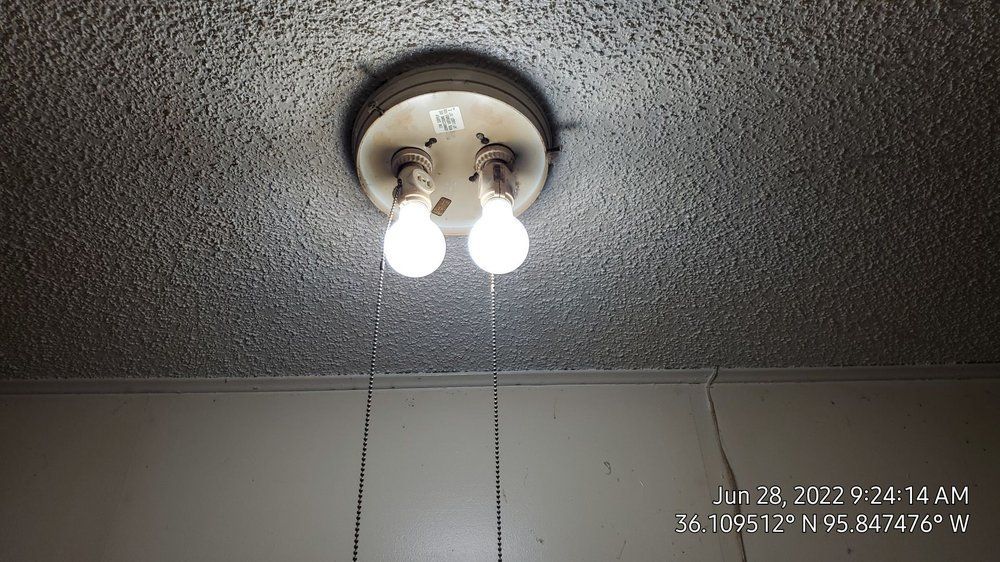 Two light bulbs are hanging from the ceiling in a room.