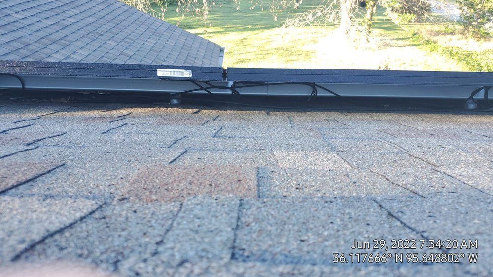 A solar panel is sitting on top of a roof.