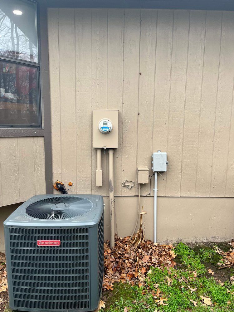 An air conditioner is sitting on the side of a house.