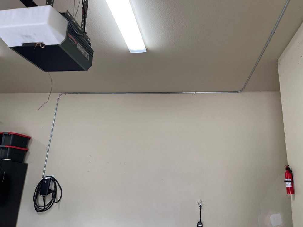 A garage door opener is hanging from the ceiling in a garage.