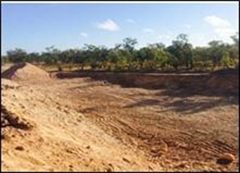 A Newly Excavated Dirt Pit with A Large Pile of Soil on One Side, Surrounded by Trees — Lamont Civil Services Pty Ltd In Townview, QLD