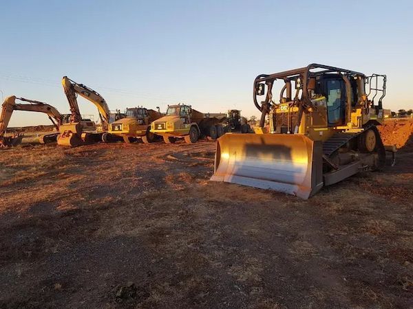 Yellow Bulldozer With Others, Parked On Dusty Ground, At Sunset — Lamont Civil Services Pty Ltd In Townview, QLD