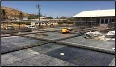 A Construction Worker Kneels on A Paved Surface, Preparing the Ground for Concrete — Lamont Civil Services Pty Ltd In Townview, QLD