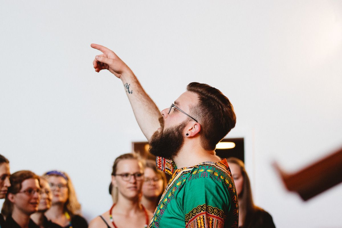 Der Chorleiter, Max-Ole Tammen, gibt den ersten Ton für seinen Chor.