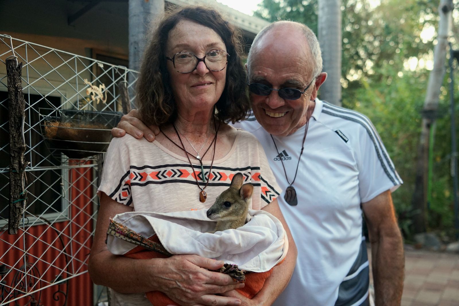 A Woman Holding A Joey And A Man Standing Next To Her -