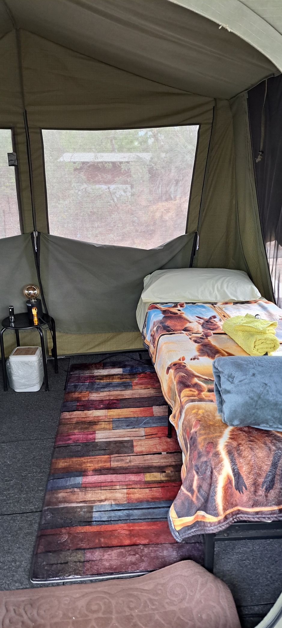 A tent with a bed and a rug inside of it — Nina's Ark Wildlife Sanctuary In Finniss Valley, NT