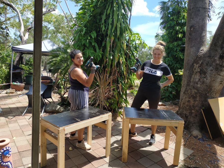 Two Women Are Standing Next to Wooden Tables on a Patio — Nina's Ark Wildlife Sanctuary In Finniss Valley, NT