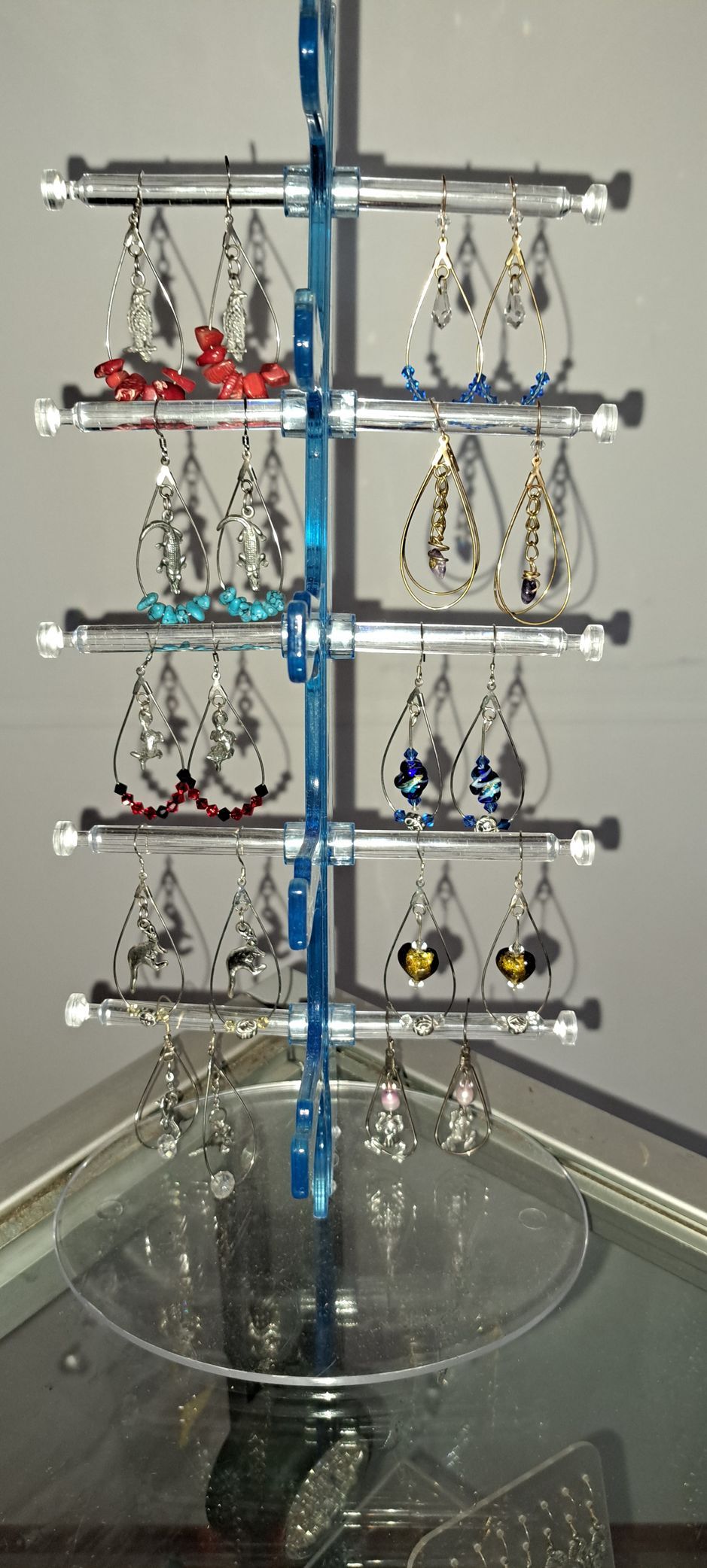 A display of earrings is sitting on a glass table.
