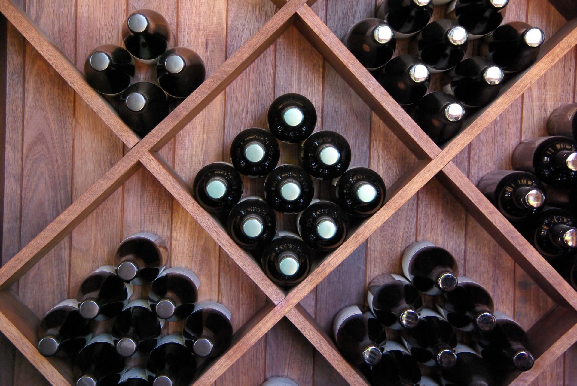 Wooden wine rack with bottles of wine.