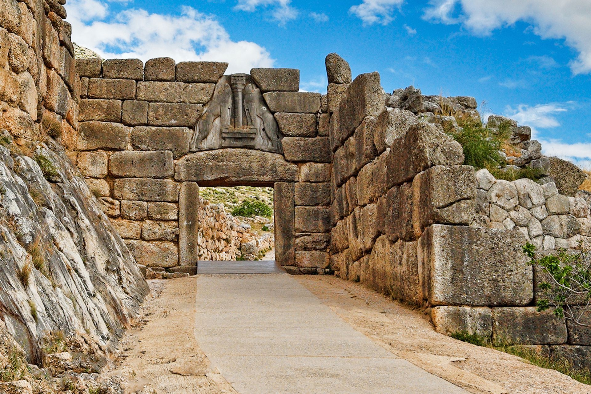 Stone-built Lion Gate entrance to Mycenae citadel in Greece; ancient, sunny day.