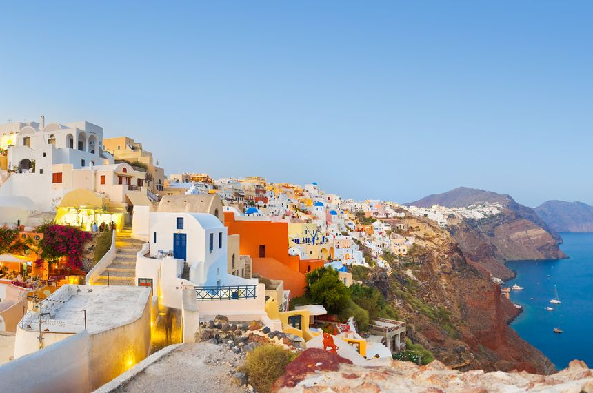 Spacious modern living room with dining area, beige and gray tones, large windows, and a colorful rug.