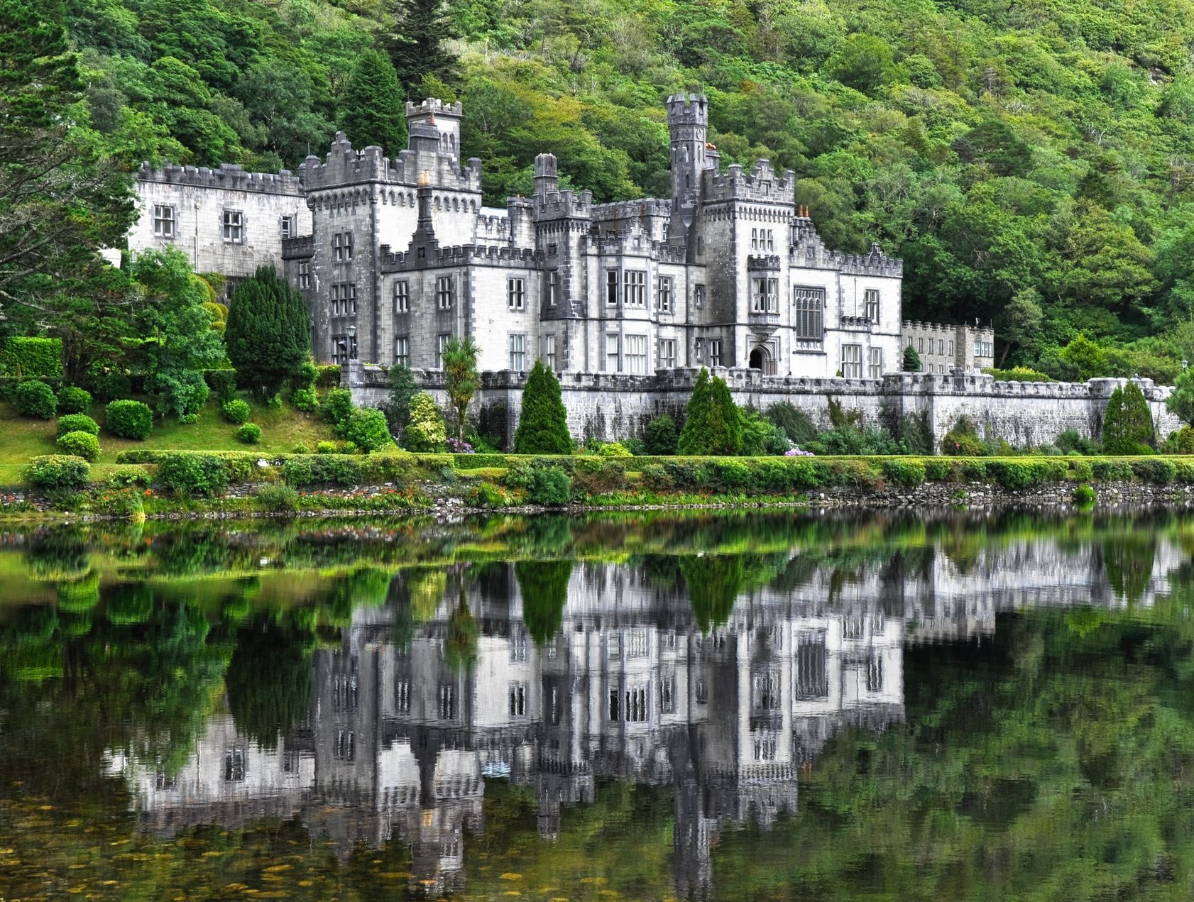 Spacious modern living room with dining area, beige and gray tones, large windows, and a colorful rug.