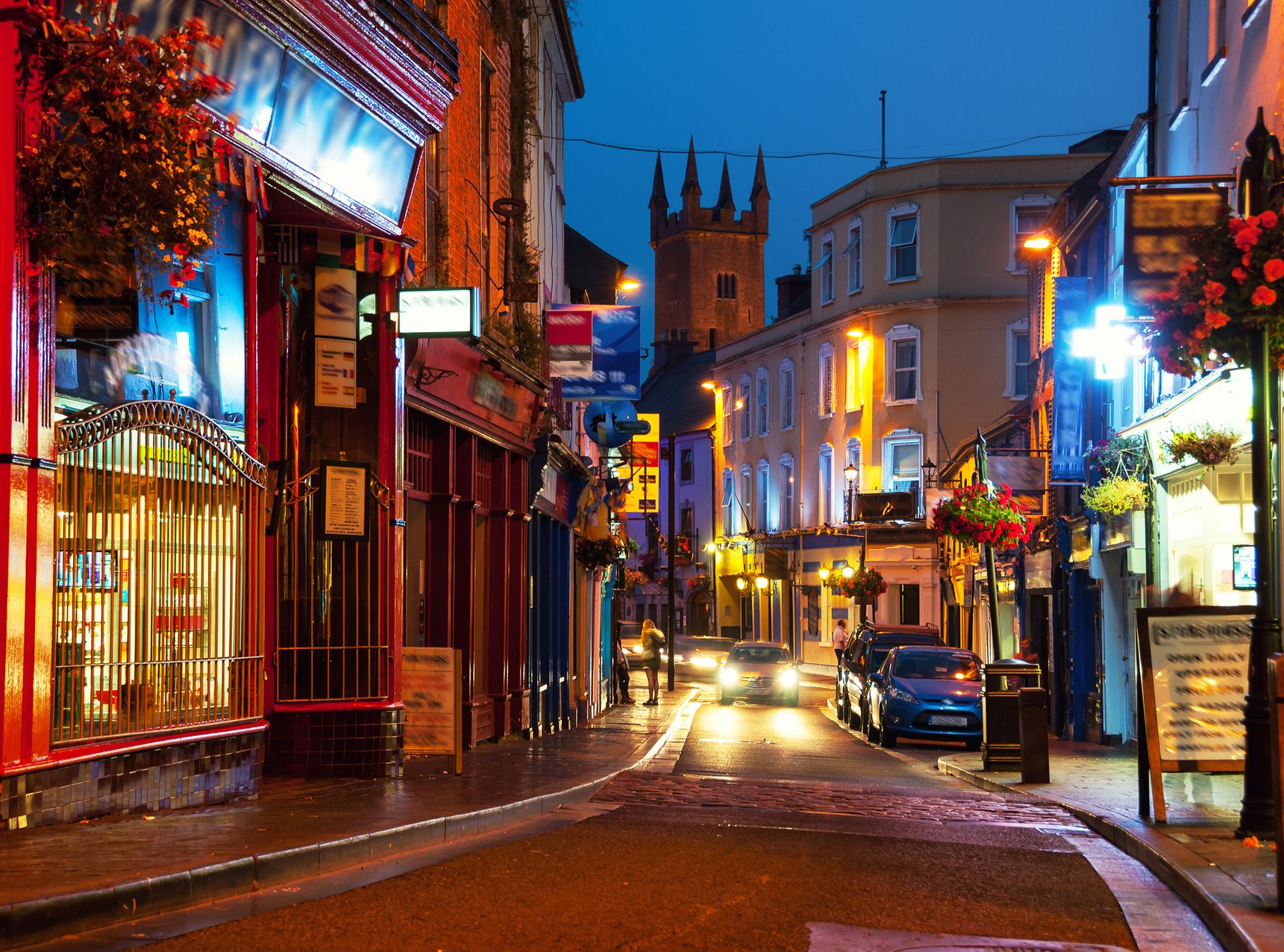 Spacious modern living room with dining area, beige and gray tones, large windows, and a colorful rug.