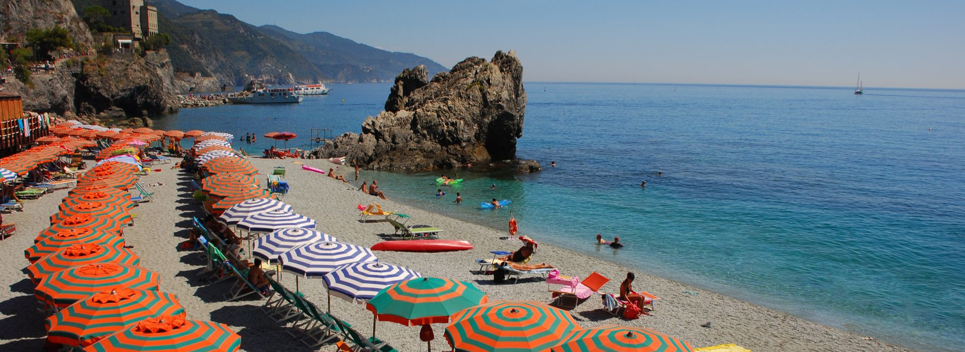 Spacious modern living room with dining area, beige and gray tones, large windows, and a colorful rug.