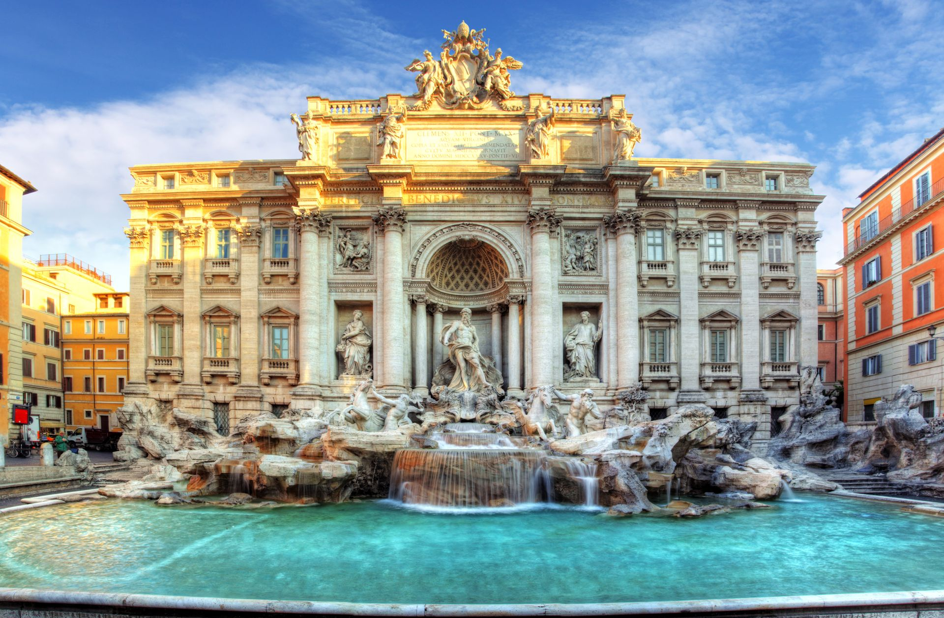 Spacious modern living room with dining area, beige and gray tones, large windows, and a colorful rug.