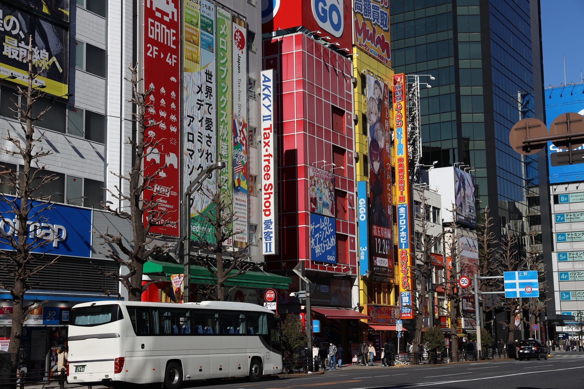 Akihabara Tokyo street with colorful anime signage, electronics shops, and busy city scene