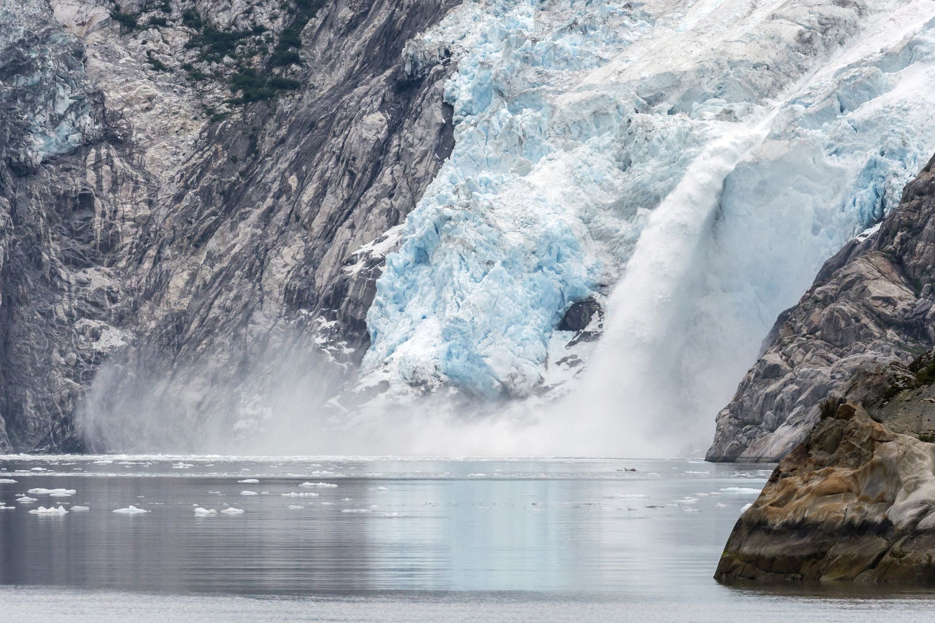 Spacious modern living room with dining area, beige and gray tones, large windows, and a colorful rug.