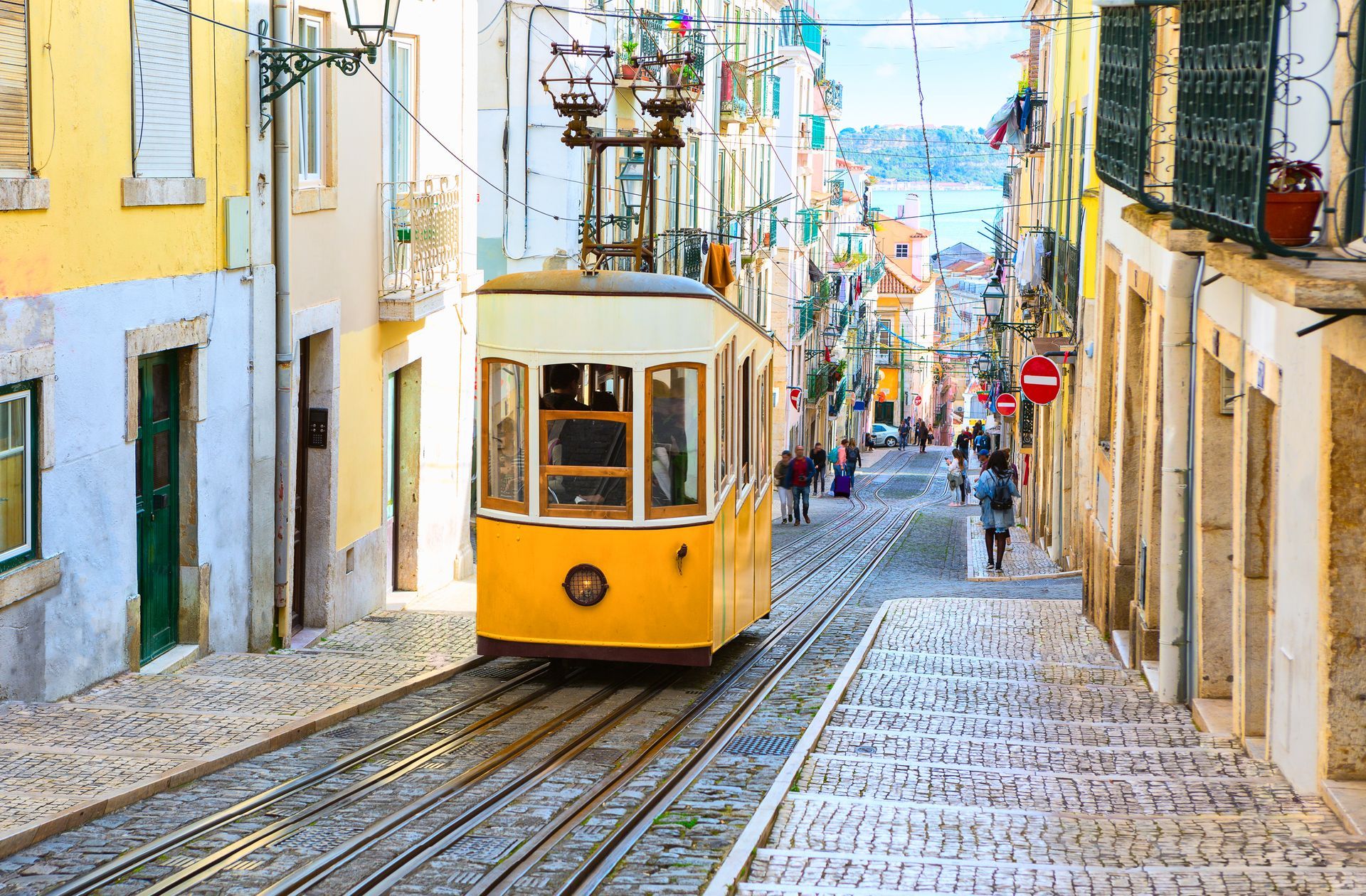 Lisbon trolley passing colorful tiled buildings in Portugal