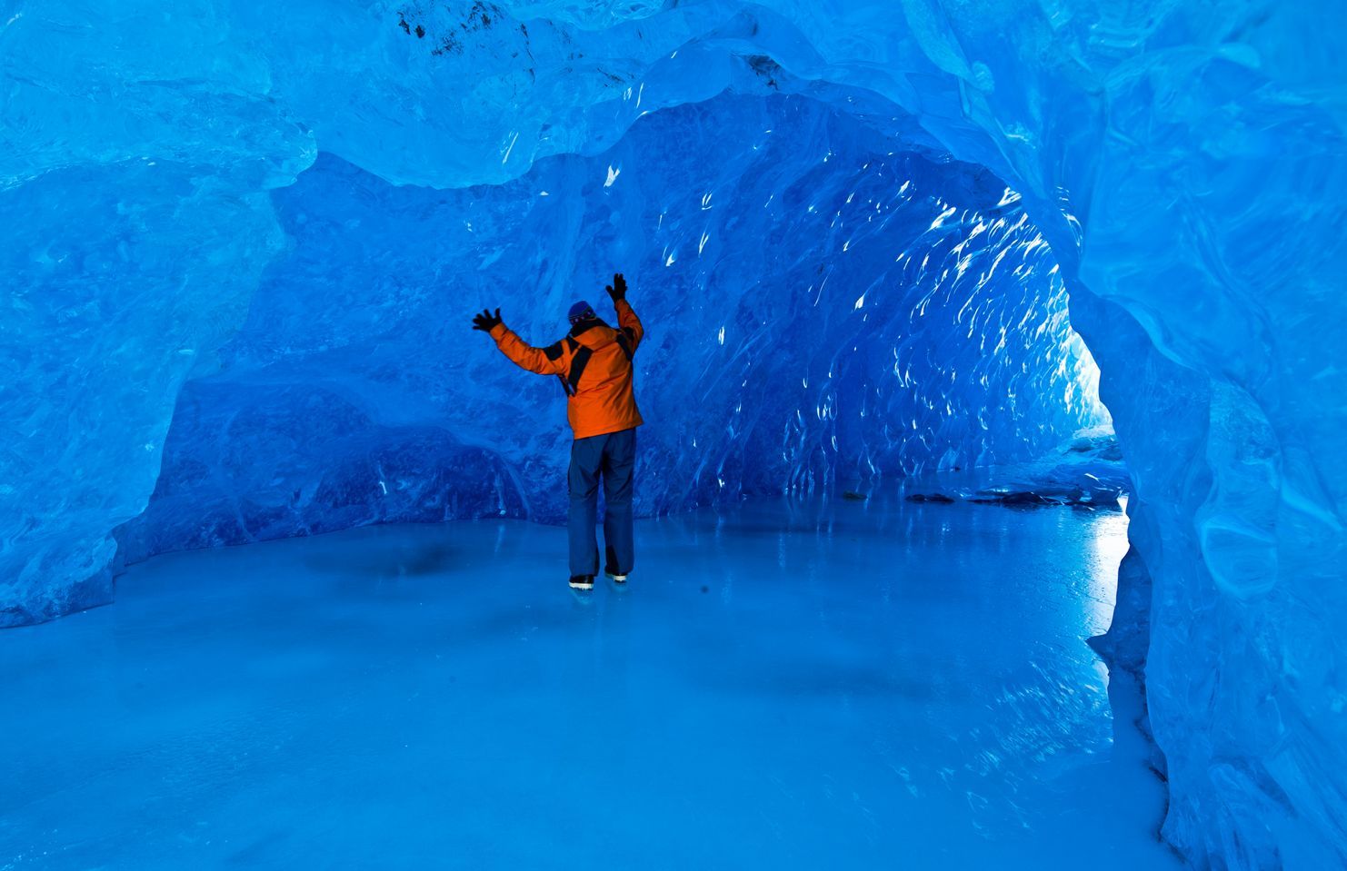 Spacious modern living room with dining area, beige and gray tones, large windows, and a colorful rug.