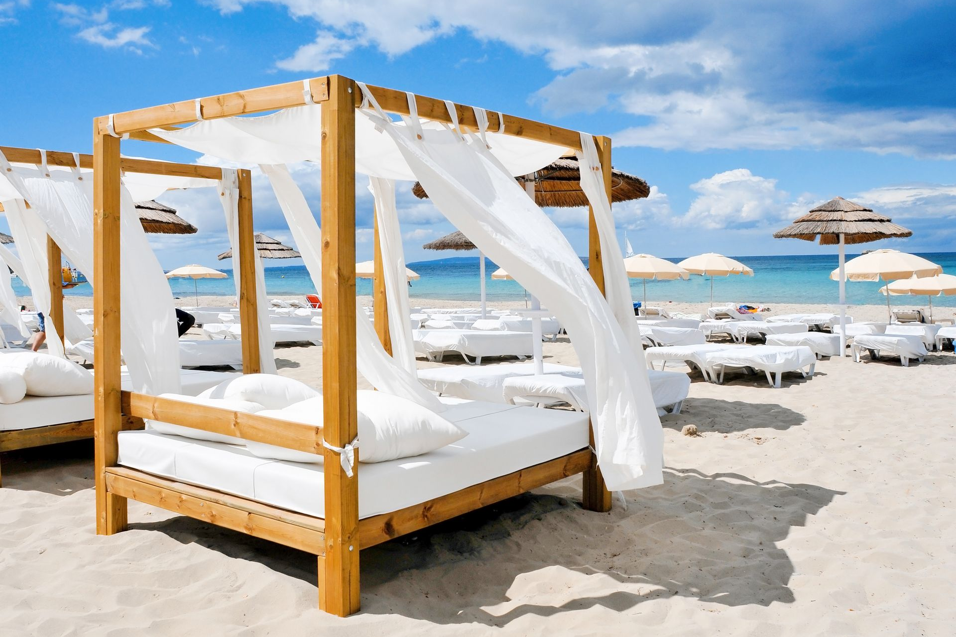 Spacious modern living room with dining area, beige and gray tones, large windows, and a colorful rug.