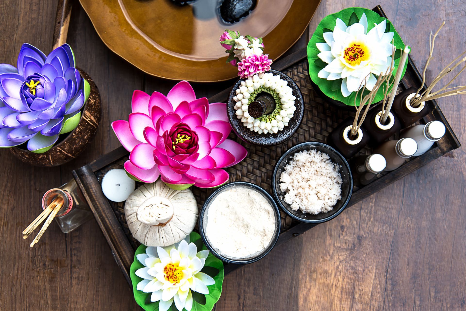 Spa treatment tray with lotus flowers, essential oils, and aromatherapy elements.