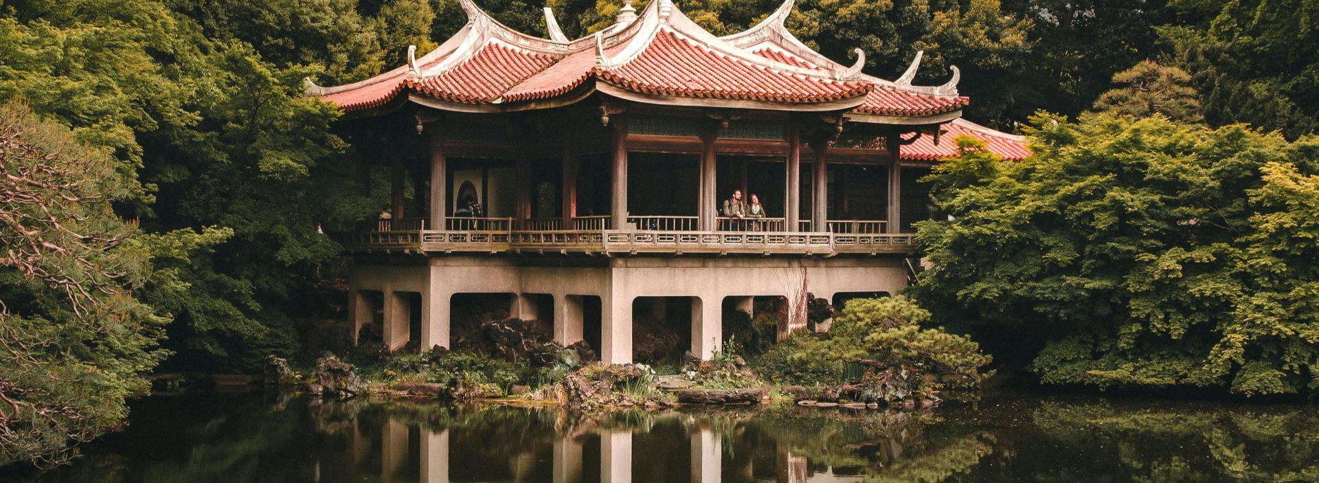 Spacious modern living room with dining area, beige and gray tones, large windows, and a colorful rug.