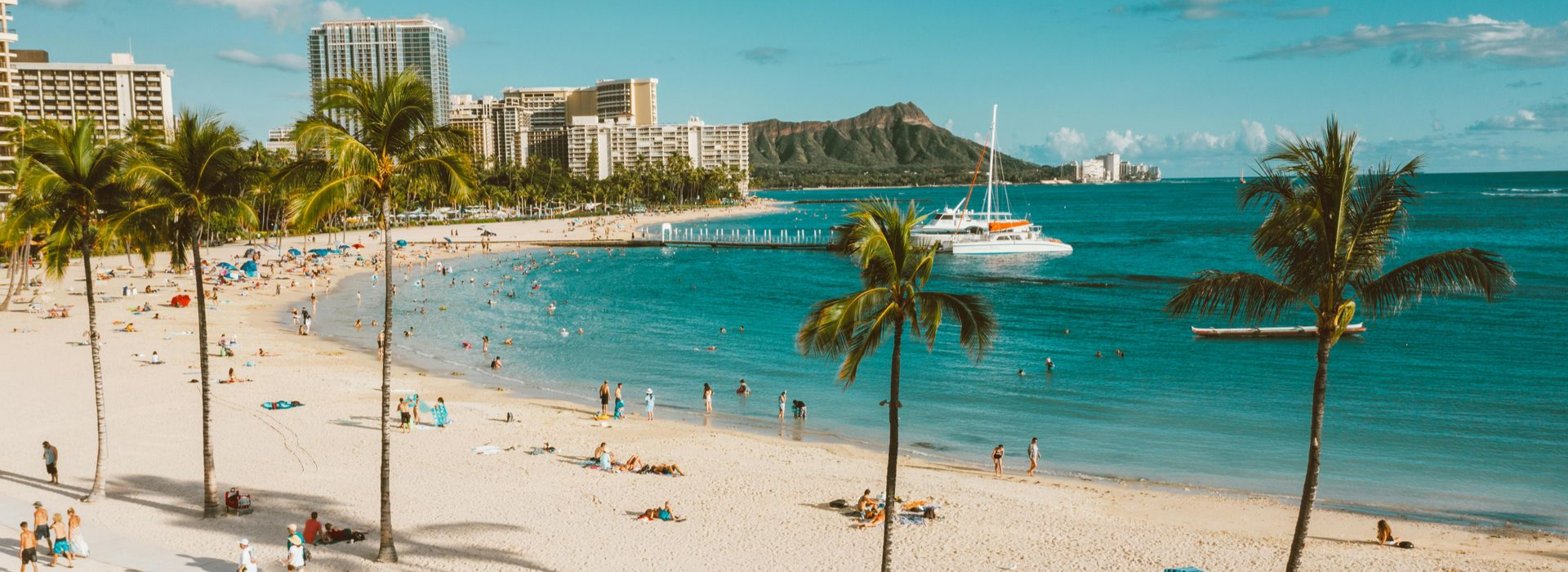 Spacious modern living room with dining area, beige and gray tones, large windows, and a colorful rug.