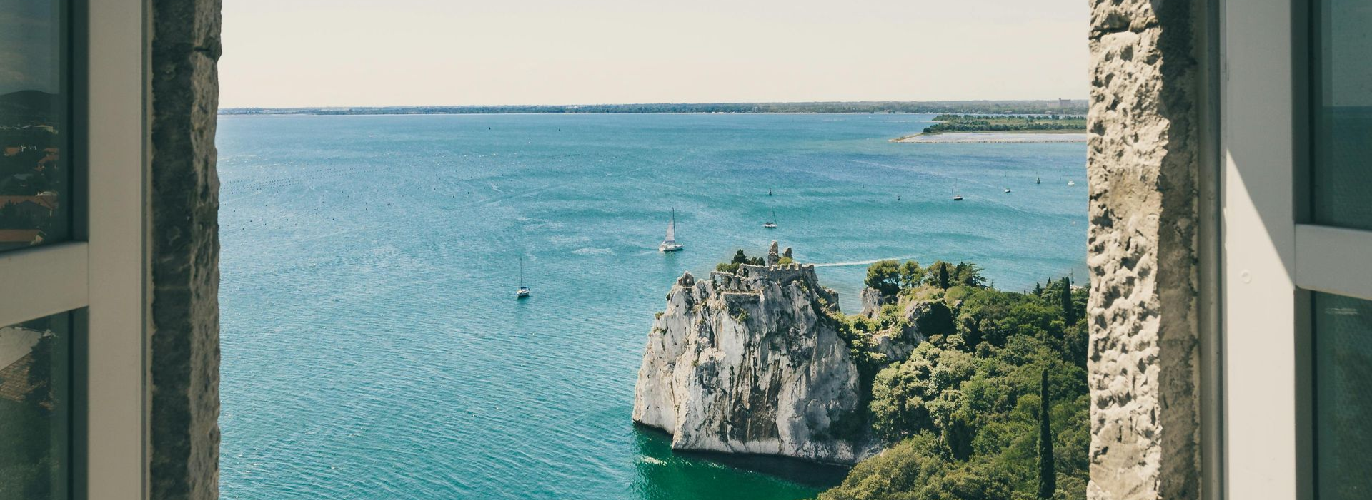 Spacious modern living room with dining area, beige and gray tones, large windows, and a colorful rug.