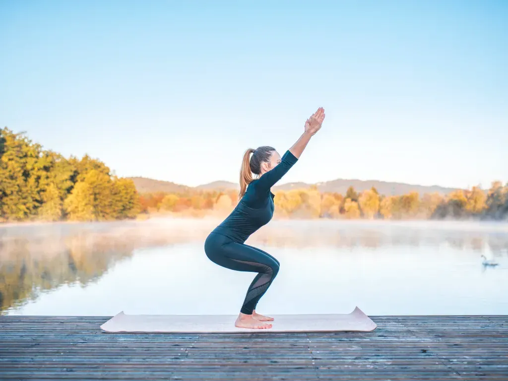 Smiling woman practices chair pose yoga for divorce