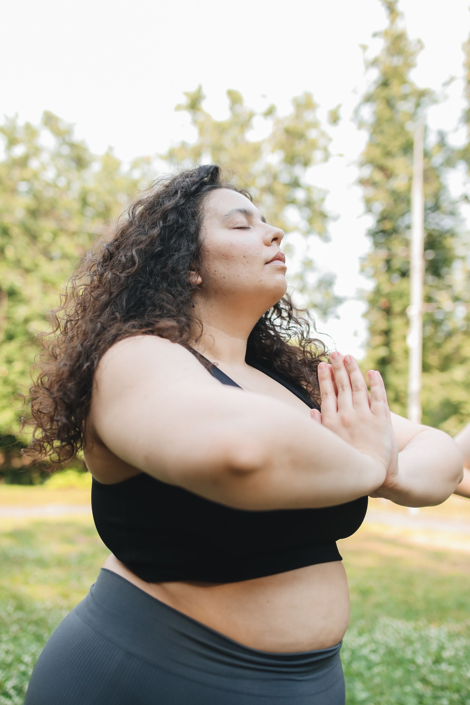 Woman with curly hair practices yoga for divorce.