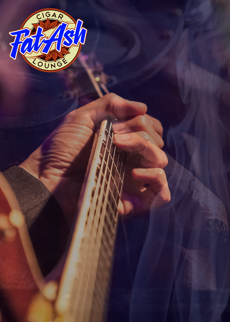 Football player in red reaching for a pass, pursued by a player in white, both on a field at night.