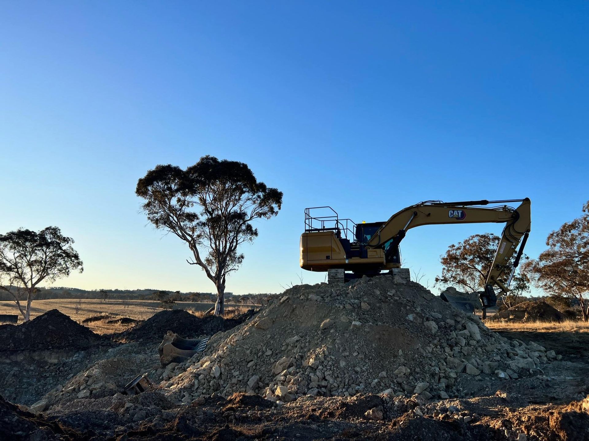 A Man Is Driving a Bulldozer on A Dirt Road — RC Civil in Armidale, NSW