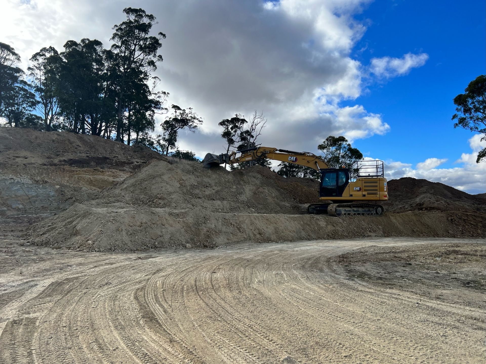 A large yellow excavator is sitting on top of a pile of dirt — RC Civil in Armidale, NSW