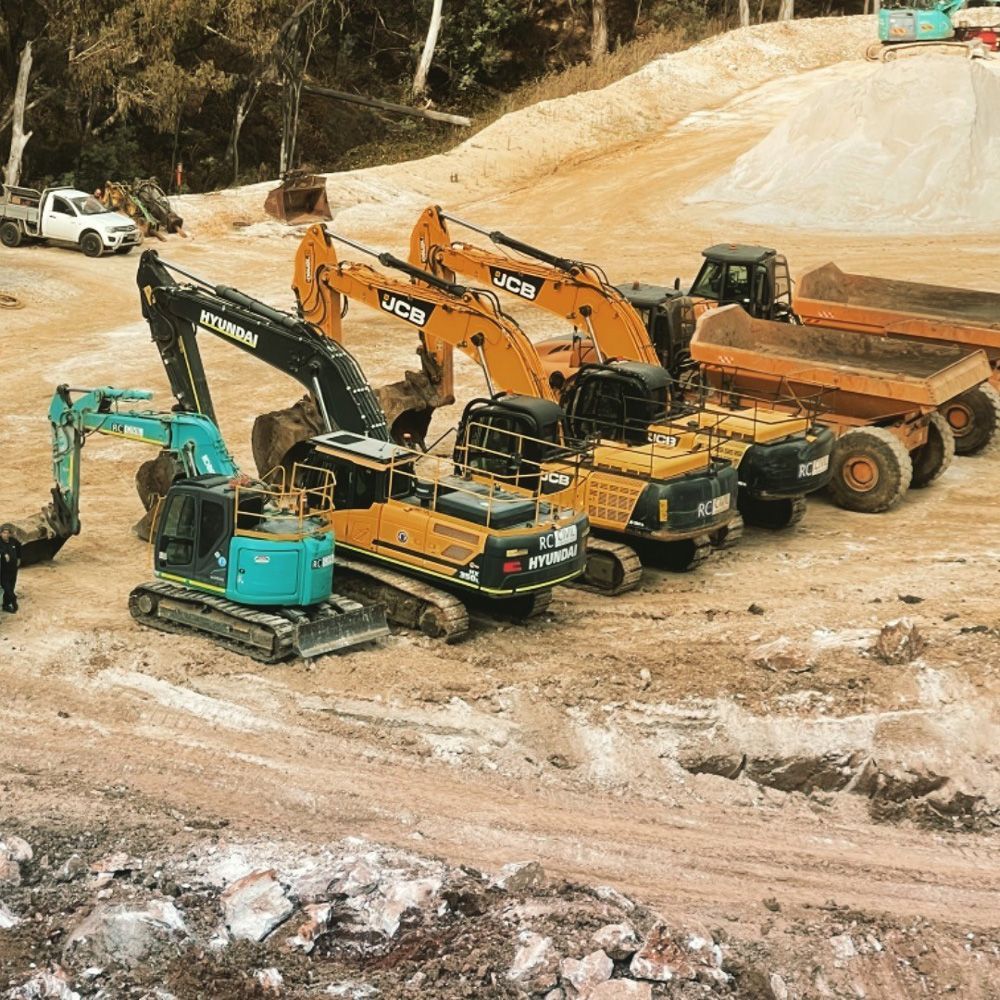 A large yellow excavator is sitting on top of a pile of dirt — RC Civil in Armidale, NSW