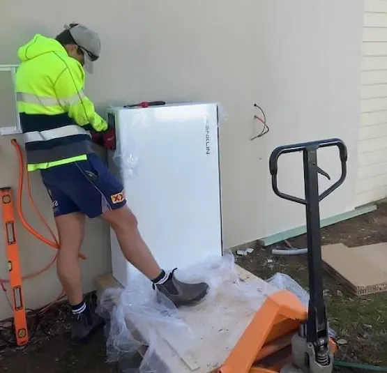 A Technician Installing a Solar Batttery — Todd Basham Electrical in Harden, NSW