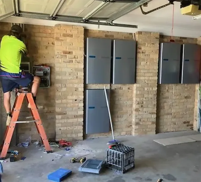 A Man on a Ladder Installing Solar Batteries — Todd Basham Electrical in Cootamundra, NSW