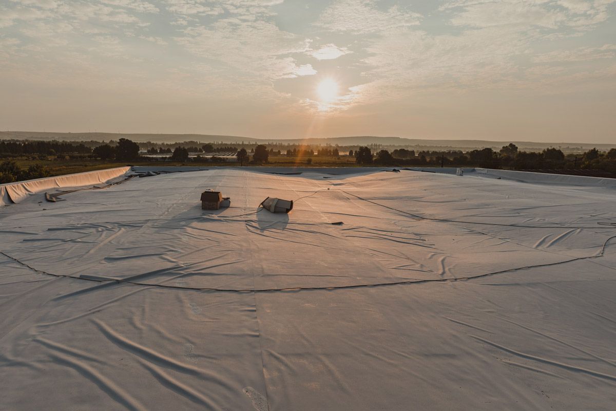 An aerial view of a roof with a sunset in the background.