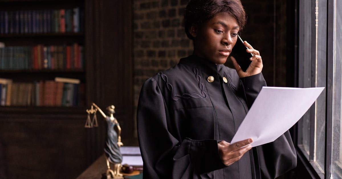 A female judge is talking on a cell phone while holding a piece of paper.