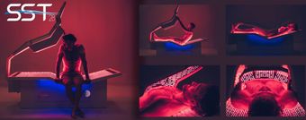 A man is sitting on a bed with red lights on it.