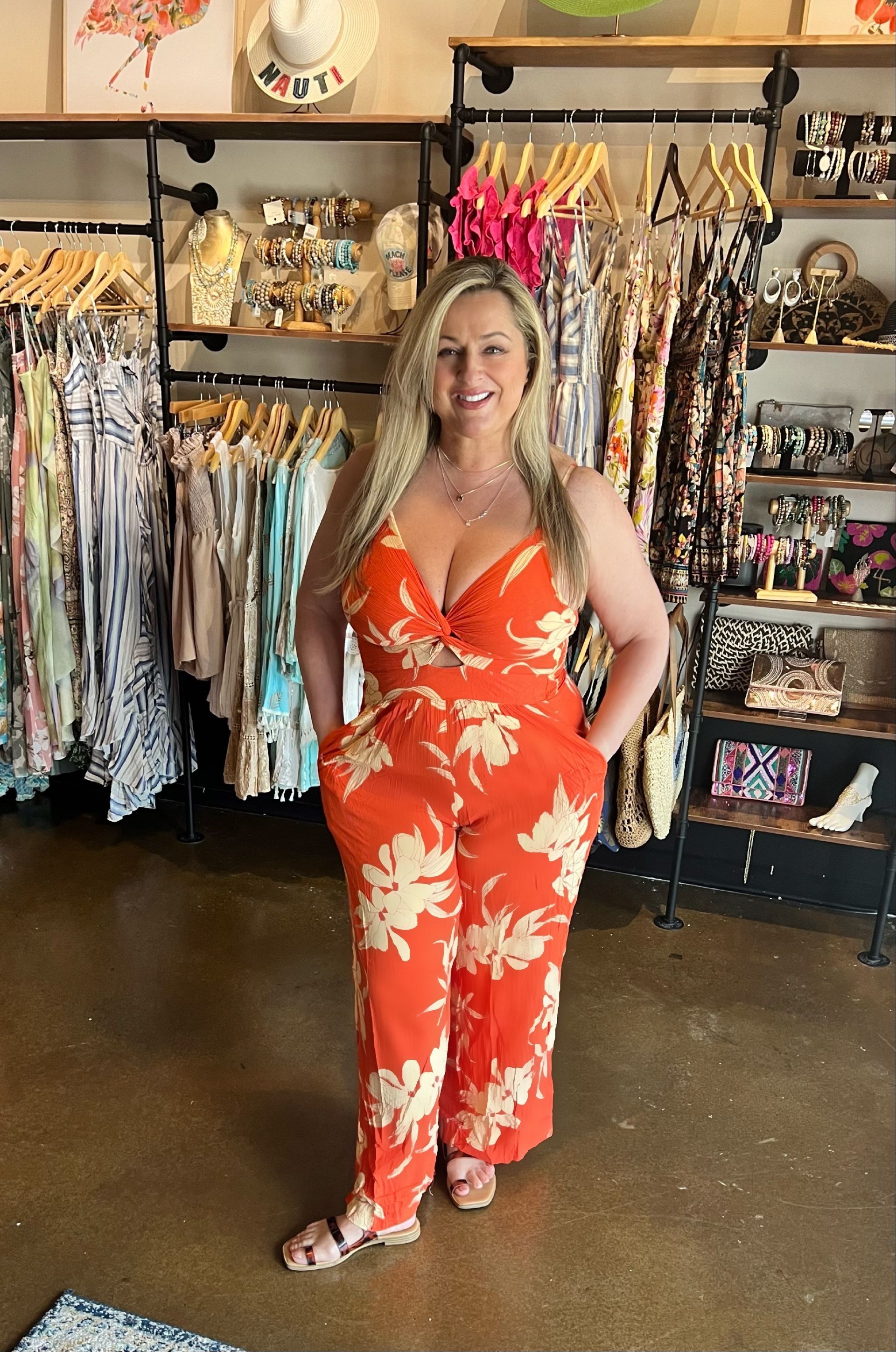 A woman in an orange jumpsuit is standing in a store.