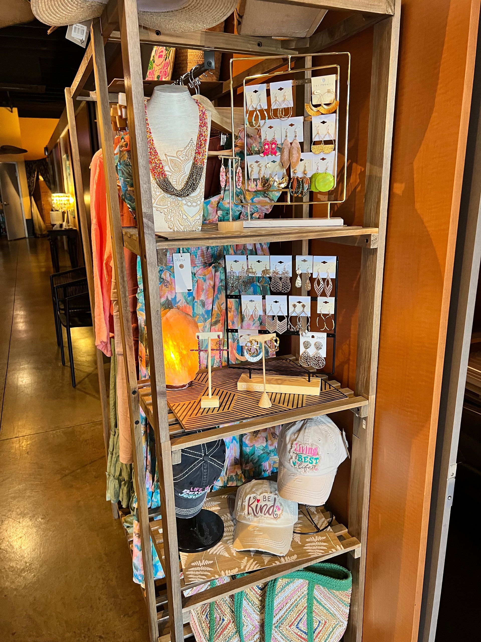 A shelf filled with lots of items including necklaces and earrings.