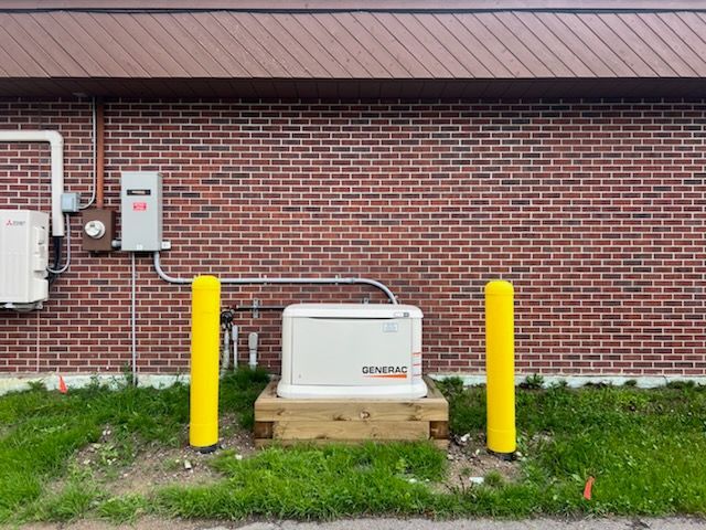 A brick building with a generator on the side of it.