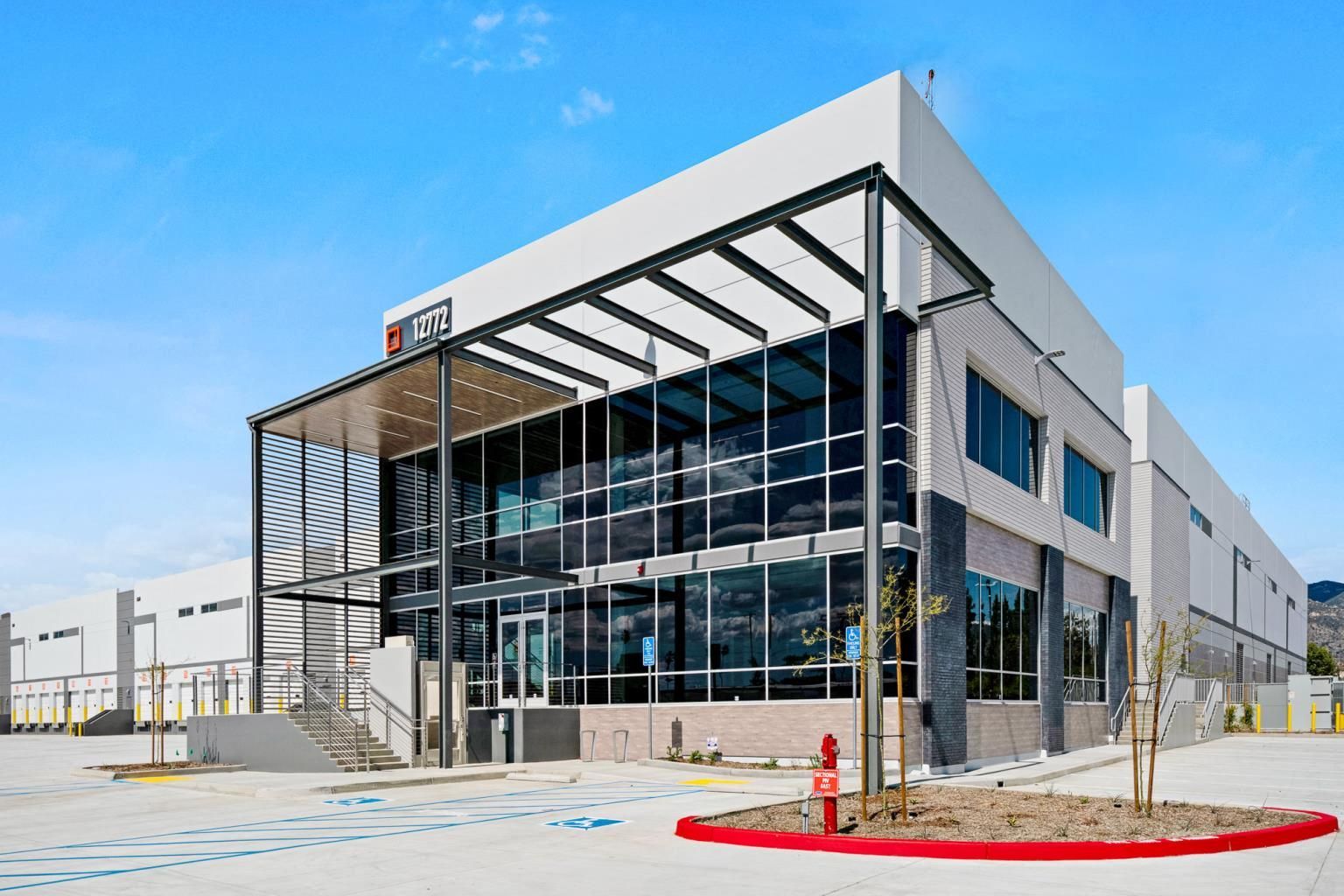 Exterior of a dental office with a gray and orange facade, blue sky, and a curved driveway.