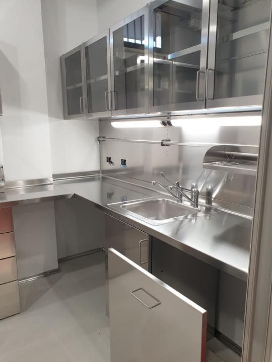 Una cucina con mobili in acciaio inox e un lavello