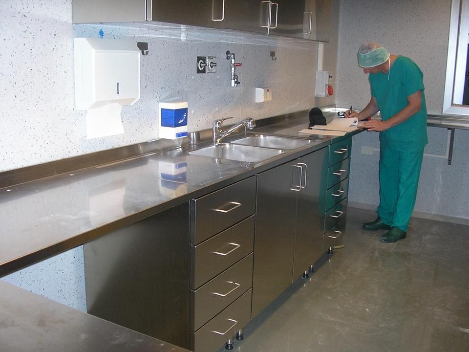 Un uomo in tuta da lavoro verde sta lavorando in cucina